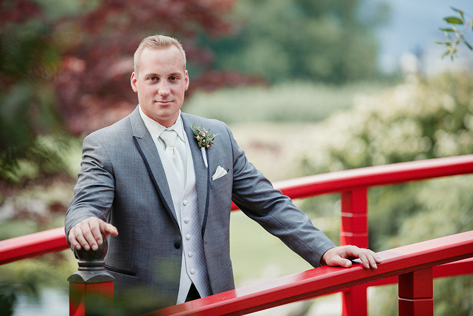 A groom stands on the red bridge at the Harvest Golf Club in Kelowna.