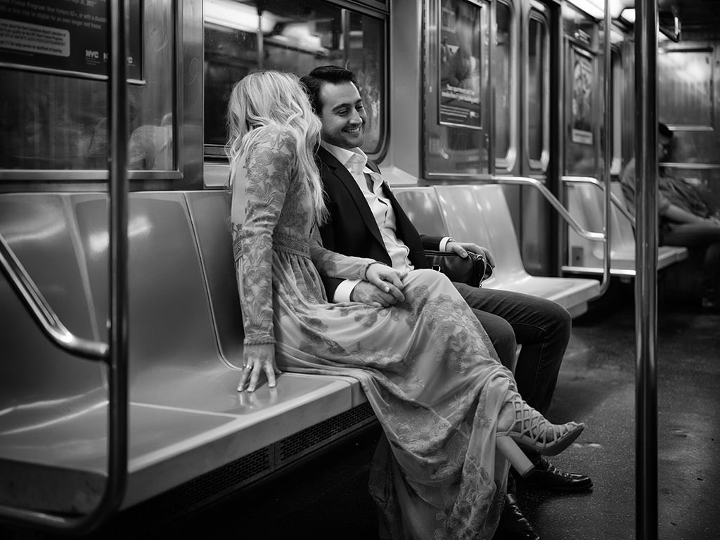 Black and white photo of lone couple on New York Subway.