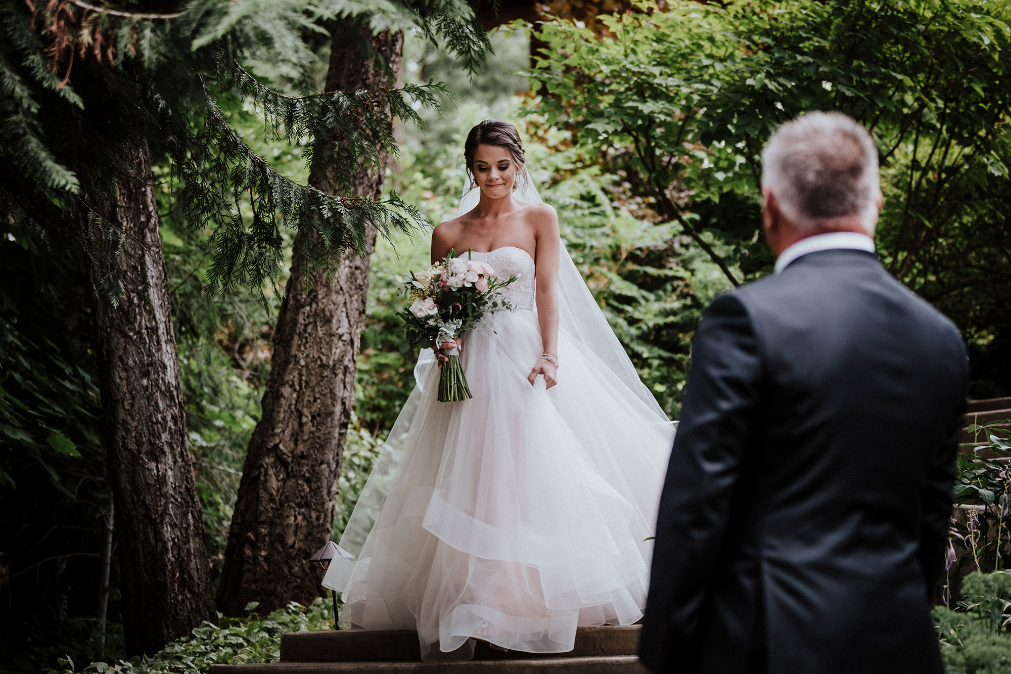 Bride descends stone staircase to her waiting father.