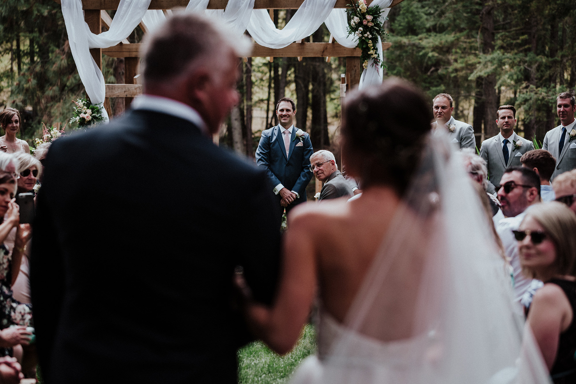Groom watches his bride come down the aisle