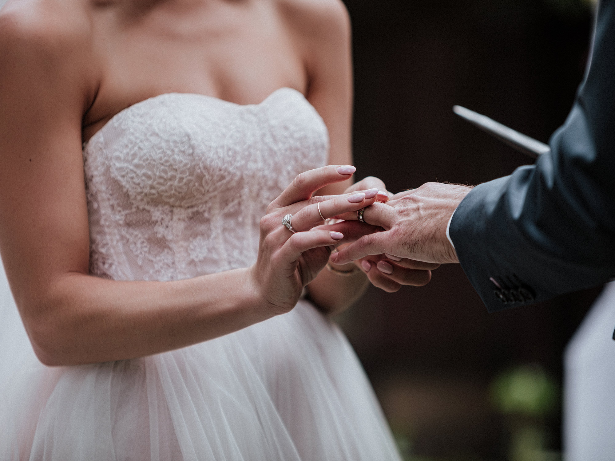 bride puts ring on groom