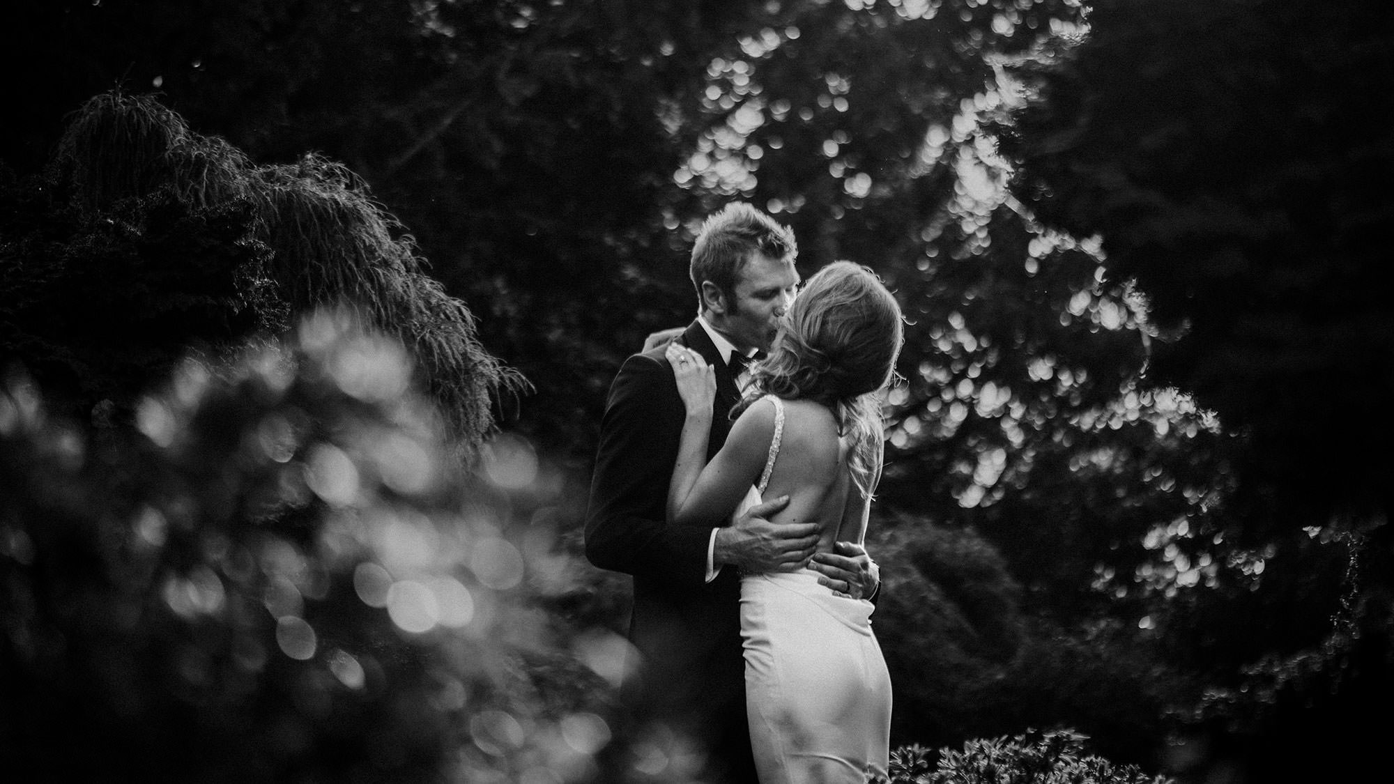 Black and white photo of groom kissing bride