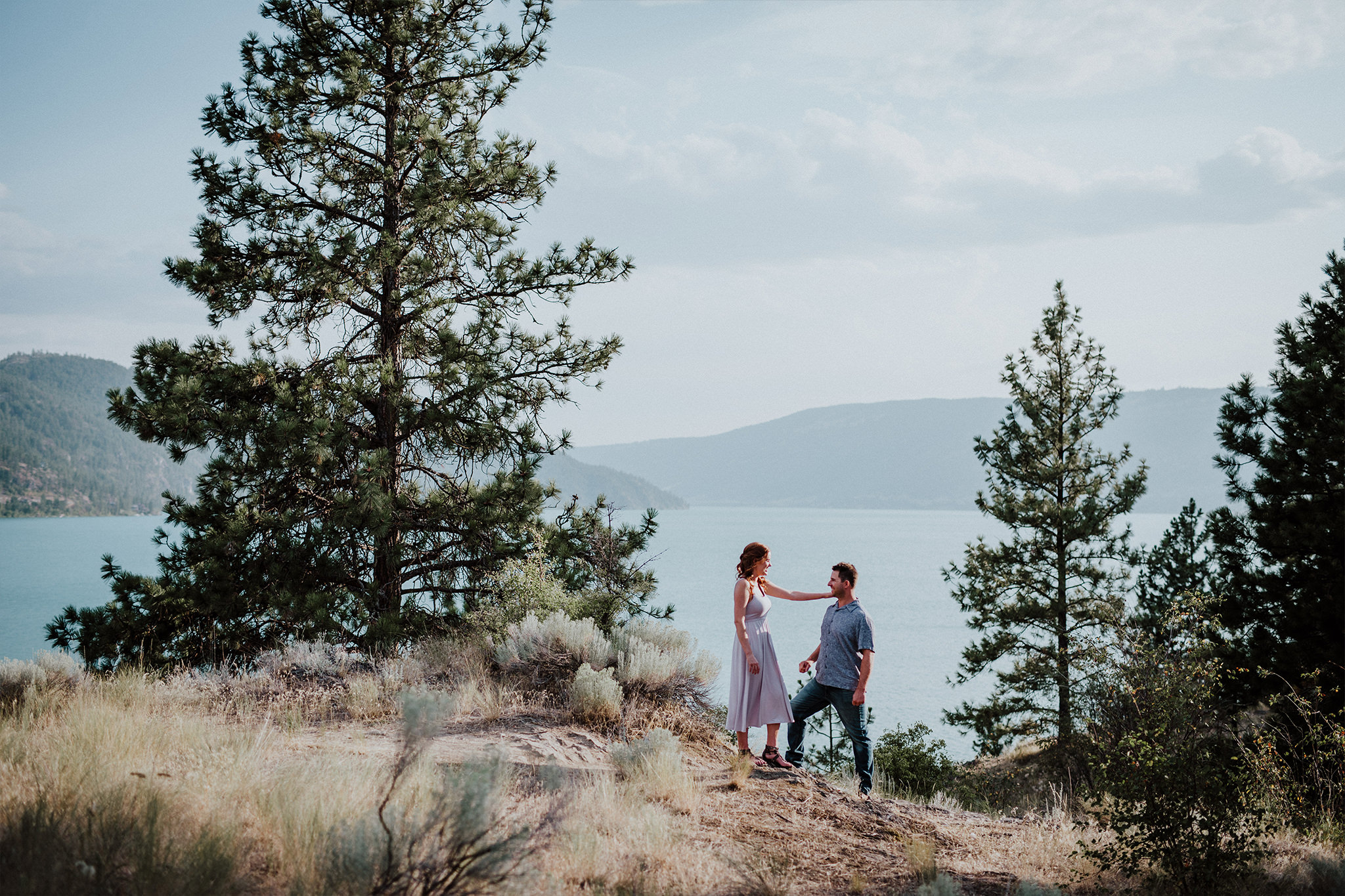 Woman and man enjoy hiking along a big lake